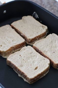 four pieces of bread sitting on top of a black pan with some brown stuff in it