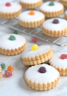 cookies with white icing and gummy bears on a cooling rack