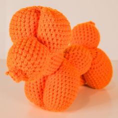 four orange knitted balls sitting on top of each other