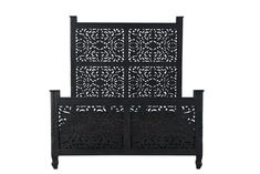 a black bed frame with intricate carvings on it