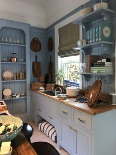 a kitchen filled with lots of blue cabinets and counter top space next to a window