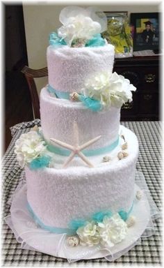 a three tiered cake with white and blue decorations