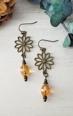 These gorgeous rustic topaz glass boho style earrings with beautiful antiqued bronze daisy dangle are a perfect addition to your Bohemian style wardrobe!  You will love wearing these unique earrings with any outfit whether casual or dressy. All of my jewelry creations come in a beautiful satin drawstring bag perfect for gift giving. Boho Earrings Diy Handmade Jewelry, Adjustable Bohemian Dangle Flower Earrings, Diy Boho Jewelry, Bohemian Czech Glass Dangle Earrings, Bohemian Brown Dangle Flower Earrings, Handmade Bohemian Flower-shaped Earrings, Bohemian Czech Glass Drop Earrings, Jewlery Earrings, Boho Jewelry Diy