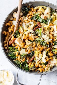 a skillet filled with pasta and vegetables