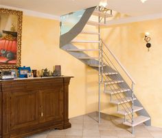 there is a stair case in the corner of this room with yellow walls and tile flooring