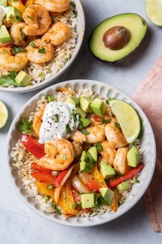 two bowls filled with shrimp and rice next to sliced avocado on the side