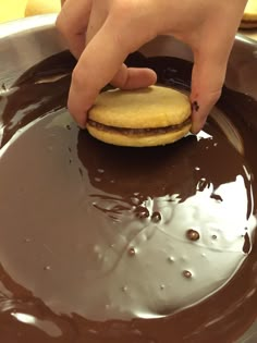 a person is dipping a cookie in chocolate