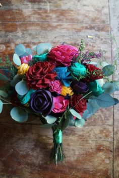 a bouquet of colorful flowers sitting on top of a wooden floor