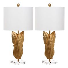 a pair of gold leaf lamps with white shades on each lamp and one light that is turned off