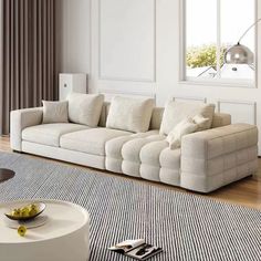 a living room filled with furniture and a large white couch in front of a window