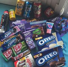 a pile of assorted snacks and drinks on a bed