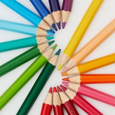 colored pencils arranged in a circle on a white surface