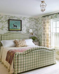 a green and white bed sitting in a bedroom next to a painting on the wall