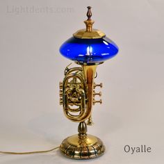 an old brass french horn table lamp with blue glass shade