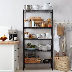 a kitchen shelving unit filled with dishes and utensils on top of metal shelves