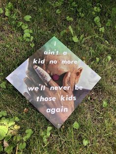 a graduation cap that has been placed in the grass with an image of a cow on it