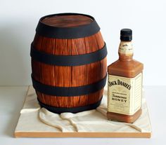 a bottle of jack daniels sitting next to a wooden barrel