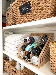 some baskets are stacked on top of the shelves with towels and other items in them