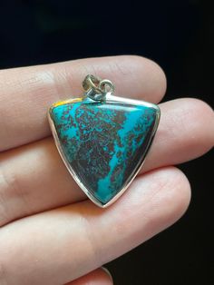 This is a gorgeous chrysocolla pendant with striking bright teal color and triangle shape! This pendant is a beautiful example of high grade Chrysocolla, it even has Hematite dendrites! Handmade and set in solid sterling silver. Size measures 26mm wide by 35mm tall (including bail) Check out some of my other Chrysocolla pendants: https://www.etsy.com/listing/1258226041/chrysocolla-pendant-large-oval-dark-blue?click_key=c42df054c1b893dc7e4ee9e0a94f8e23f1690870%3A1258226041&click_sum=51591c65&ref=related-1&frs=1 https://www.etsy.com/listing/1244234164/chrysocolla-pendant-with-hematite?ref=listings_manager_grid Turquoise Triangle Jewelry For Gifts, Turquoise Triangle Jewelry Gift, Blue Turquoise Chrysocolla Necklace With Large Pendant, Artisan Chrysocolla Pendant Necklace, Chrysocolla Large Pendant Jewelry Gift, Blue Chrysocolla Pendant Necklace, Nature-inspired Chrysocolla Pendant Jewelry, Sterling Silver Necklace Pendants, Triangle Shape