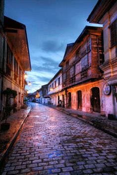 an empty cobblestone street at dusk