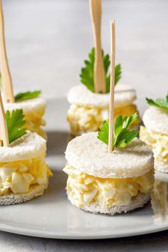 mini eggs and cheese sandwiches on a plate with toothpicks sticking out of them