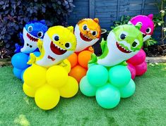 there are many balloons in the shape of animals on the grass, and some have teeth