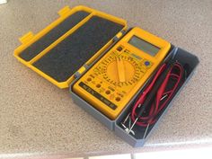 a yellow and black box with some tools in it on a counter top next to a pair of scissors