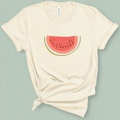 This minimal watermelon graphic t-shirt with its subtle retro feel comes straight from the pages of yesteryear. This wedge of watermelon graphic tee is supper sweet without being sticky. Its a perfect companion for your a pair of jean shorts and a hot summer day. DETAILS This medium weight graphic t-shirt is super soft, comfy. It fits like a well loved favorite tee the first time you put it on, and is soon to become your go to tee. This durable crew neck, short sleeve shirt is made with superior Pink Fruit Print T-shirt For Summer, Watermelon Graphic Print T-shirt For Summer, Watermelon Cotton Short Sleeve Top, Green Graphic Tee With Fruit Print, Casual Watermelon T-shirt With Graphic Print, Pink Short Sleeve T-shirt, Watermelon Graphic, Watermelon Shirt, Cut Tees