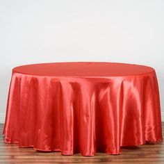 a red table cloth on top of a wooden floor in front of a white wall