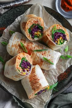 a plate filled with some tasty looking burritos on top of wax paper