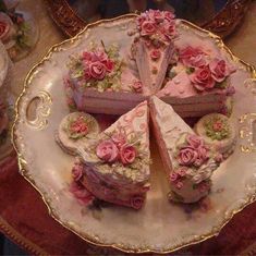 there are several pieces of cake on the plate with pink flowers and roses around it