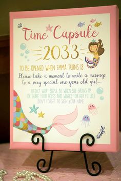 a sign that says time capsule on the front and back of it with an image of a mermaid