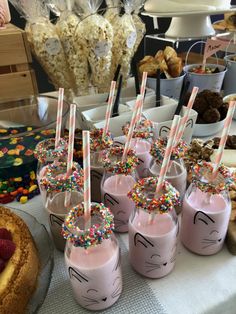 there are many desserts on the table with strawberries and milkshakes in them