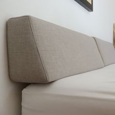 the corner of a bed with a pillow on it