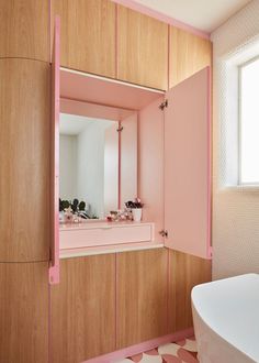 a bathroom with pink and white decor on the walls, sink and bathtub in it