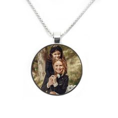 two women are holding each other on a necklace