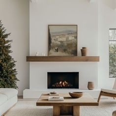 a living room filled with furniture and a fire place in front of a christmas tree