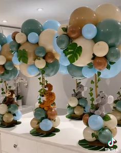 balloons are arranged in the shape of animals and plants on display at a party or baby shower