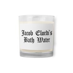 a candle that is sitting on top of a white surface, with the words tattoo clouds bath water written in black ink