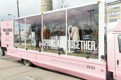 a pink truck parked in front of a tall building