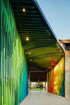 an artistic building with multicolored lines on the wall and walkway leading up to it