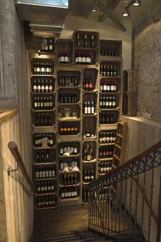 a staircase leading to a wine cellar filled with bottles