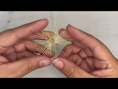 two hands are holding a piece of paper that is shaped like a starburst