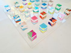 an array of different colored geometric shapes on a white surface with clear acrylic paint