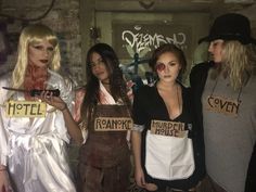 three women dressed up as zombies holding signs