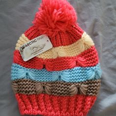 a knitted hat with multicolored stripes and a tag on the front that says majestic park