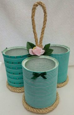 three baskets with flowers are sitting on rope