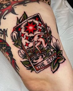 a tattoo on the leg of a person with red and green stars in it's center