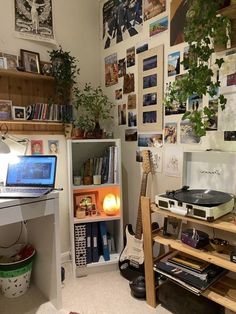 a room with a record player, desk and shelves full of books on the wall