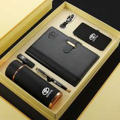 an open box containing a pen, camera and other personal items in it's display case